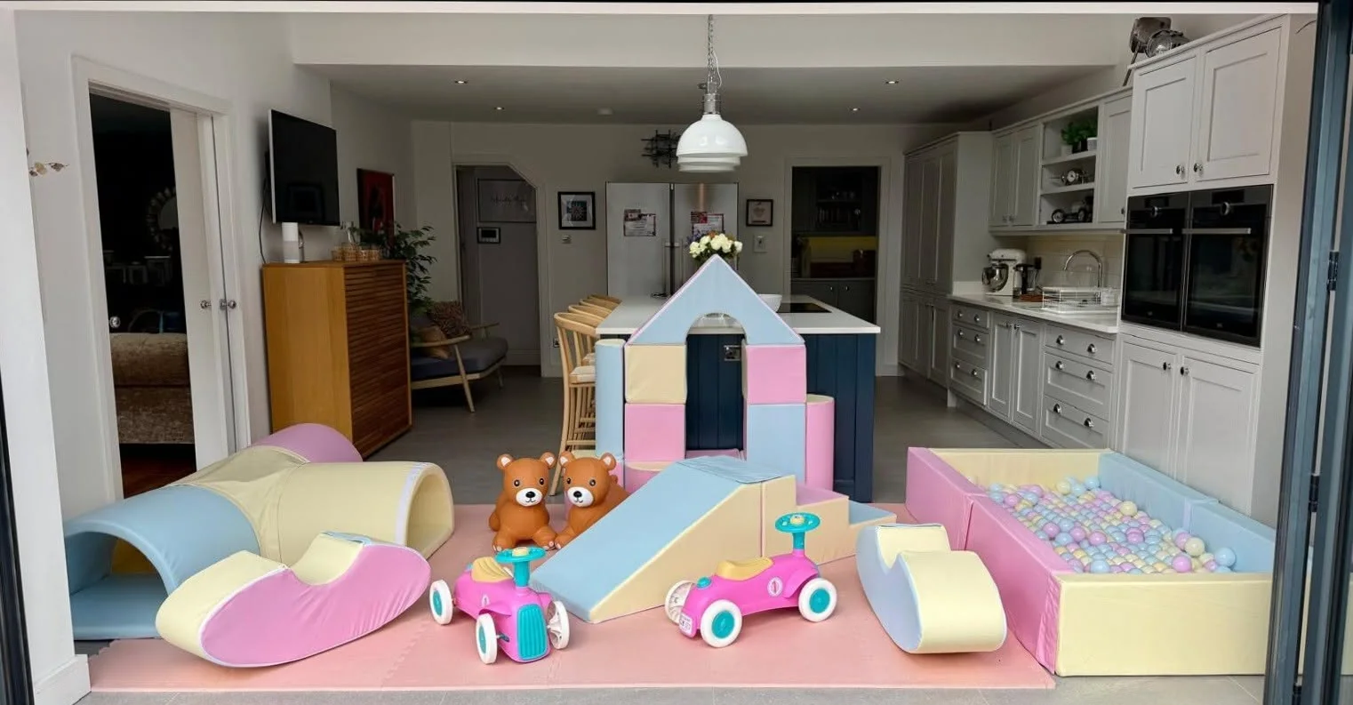 Pastel Play Parcel soft play setup with ball pit, slide, castle blocks and ride-ons